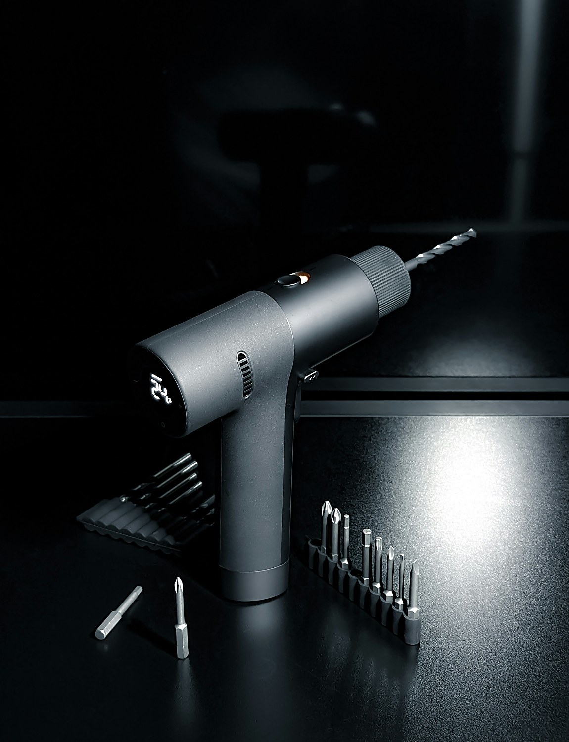 Cordless power drill with an assortment of drill bits and screwdriver bits laid out